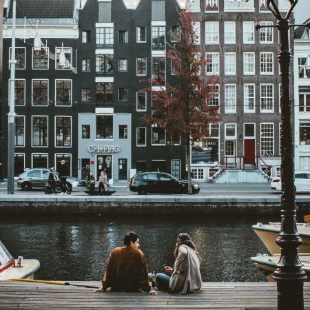 couple in amsterdam sitting on canal